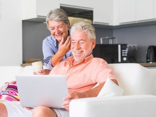 Anziani sul divano utilizzano il pc