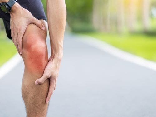 Uomo si tocca il ginocchio dolorante